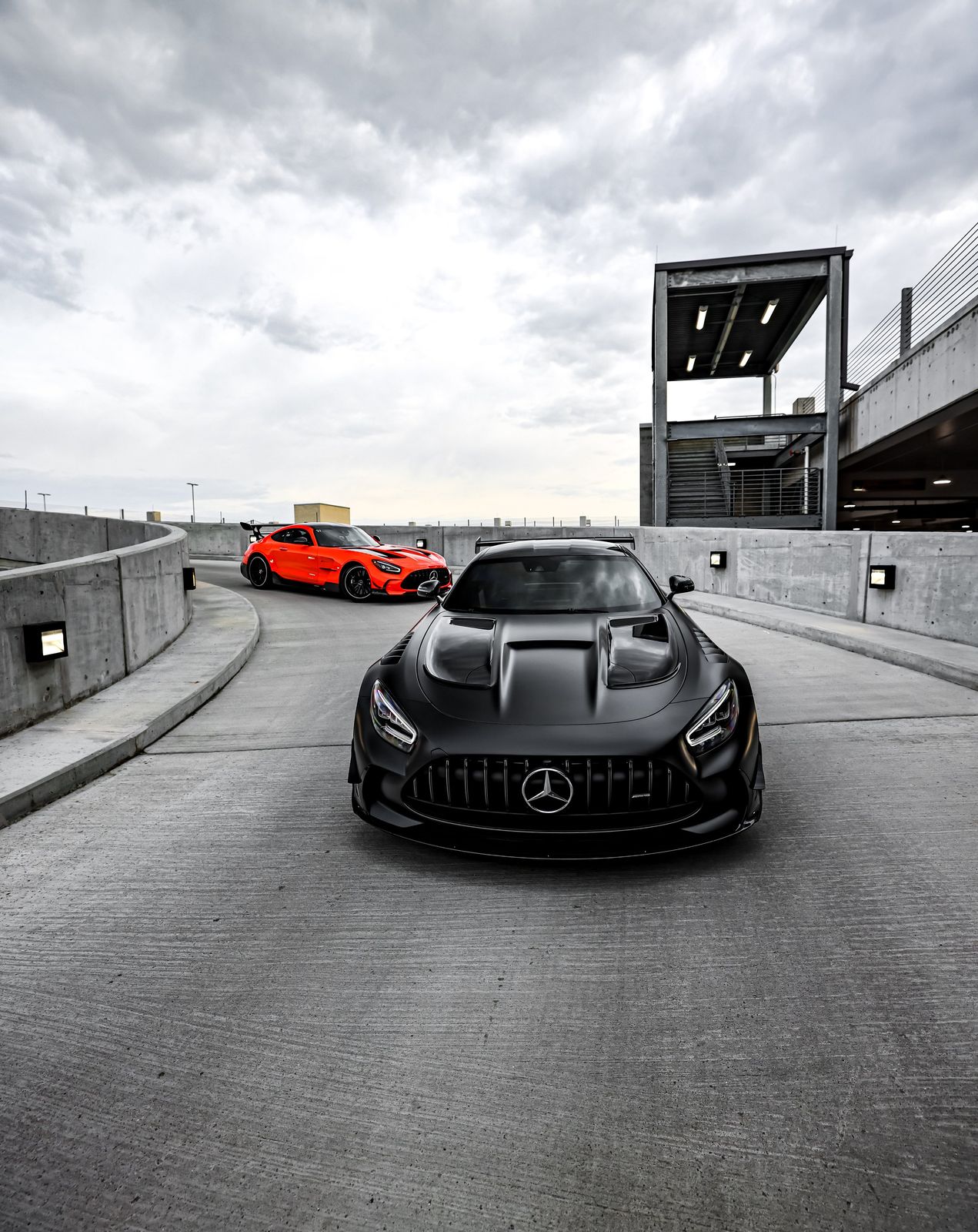 Black Mercedes-Benz sports car in the front, red sports car in the background, o
